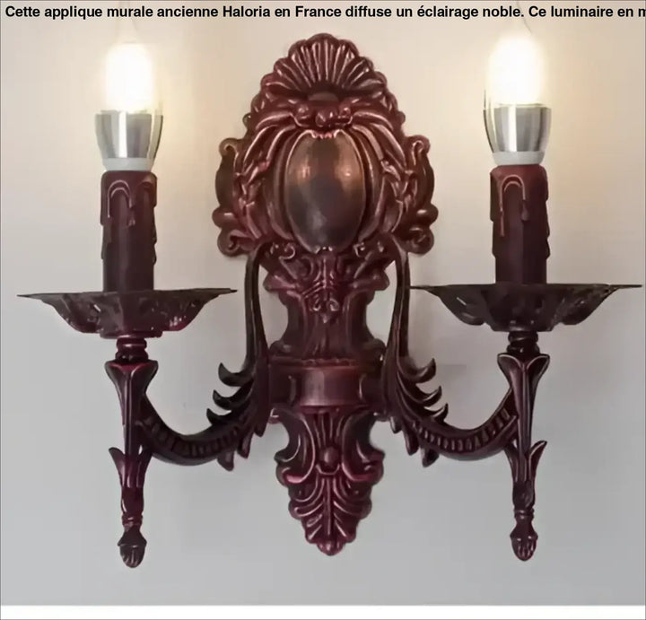Applique murale ancienne en burgundy foncé à deux luminaires avec bras bougie et arabesques décoratives haloria