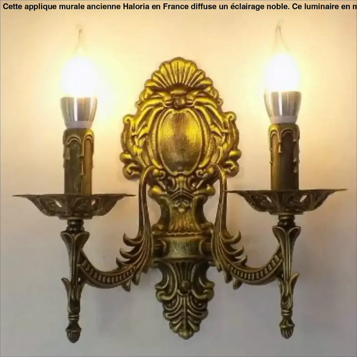 Applique murale ancienne en métal doré antique avec design orné symétrique et deux ampoules style bougie haloria