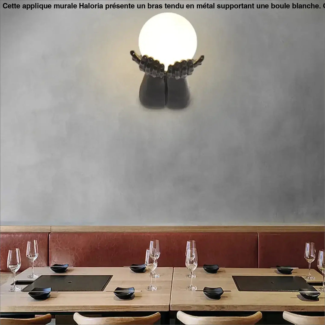 Applique murale avec brand tendu tenant une boule blanche


