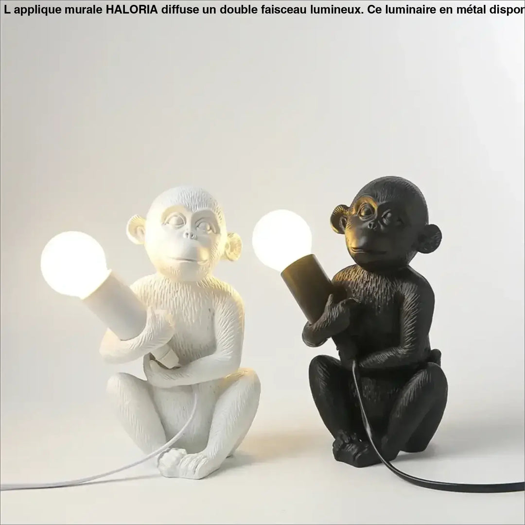 Lampe de table zaboo avec singe assis en résine blanche et noire tenant une ampoule lumineuse sculpturale singe assis