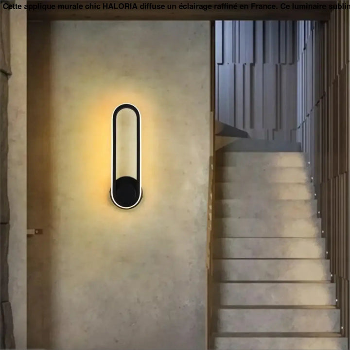 Applique murale chic noire ovale moderne avec design minimaliste et éclairage ambiant chaleureux haloria