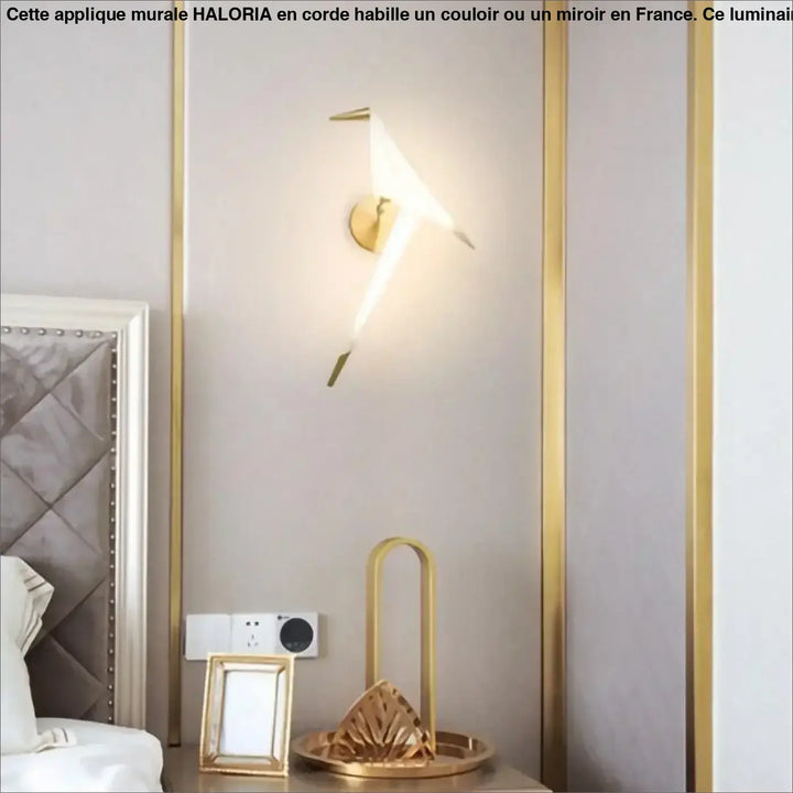 Applique murale haloria couleur or en forme d’oiseau stylisé avec bras métalliques et corps lumineux idéale long d’un couloir ou autour d’un miroir