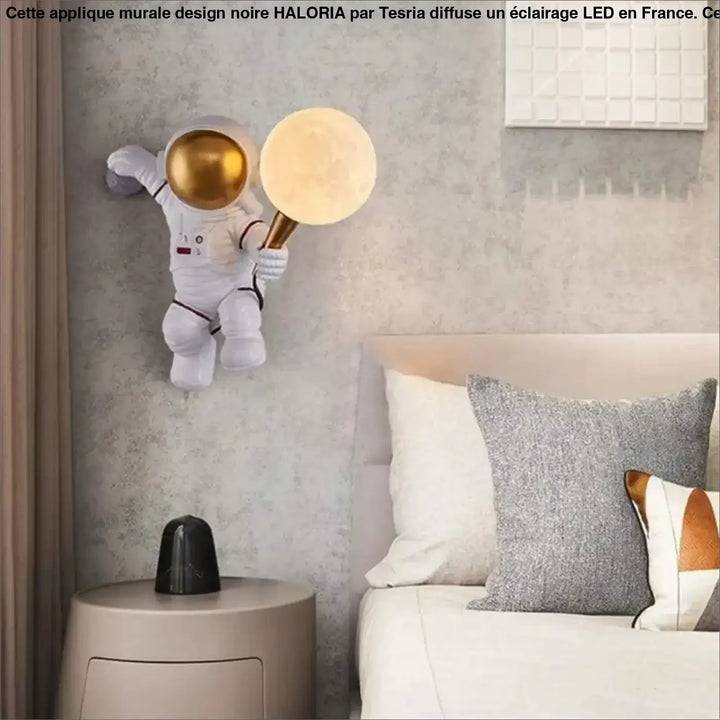Applique murale design HALORIA blanche avec casque doré tenant une lampe murale design lune lumineuse dorée