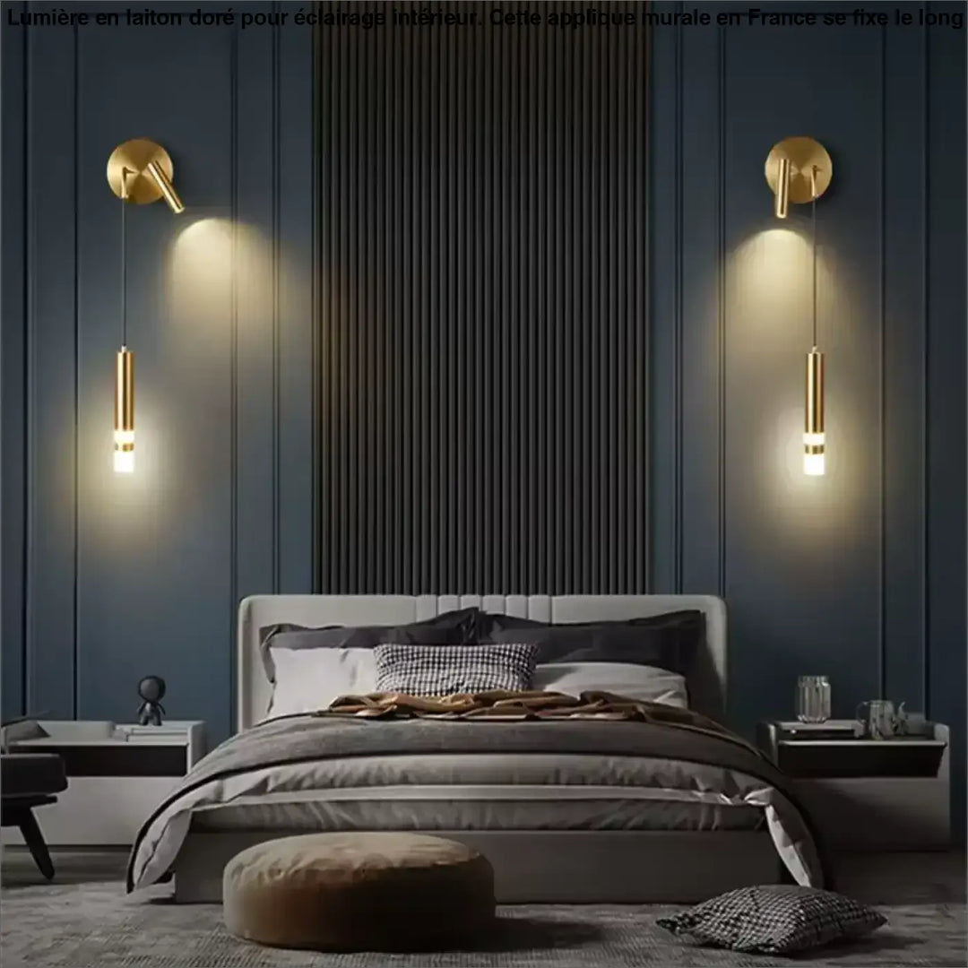 Applique murale en laiton aurelia avec luminaires cylindriques dorés encadrant un miroir sur un mur bleu marine