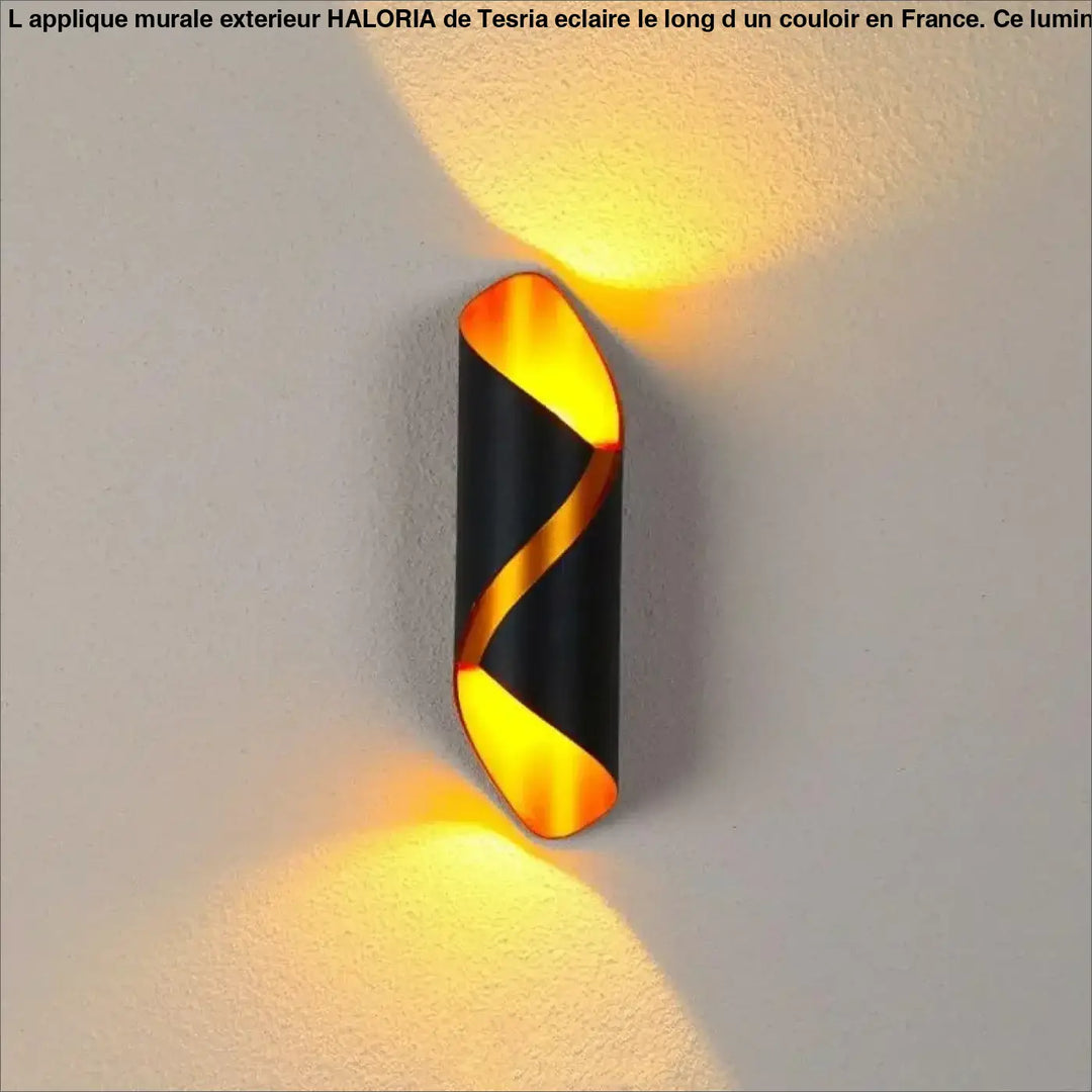 Applique murale exterieur haloria noire et dorée torsadée émettant une lumière ambiante chaude en extérieur