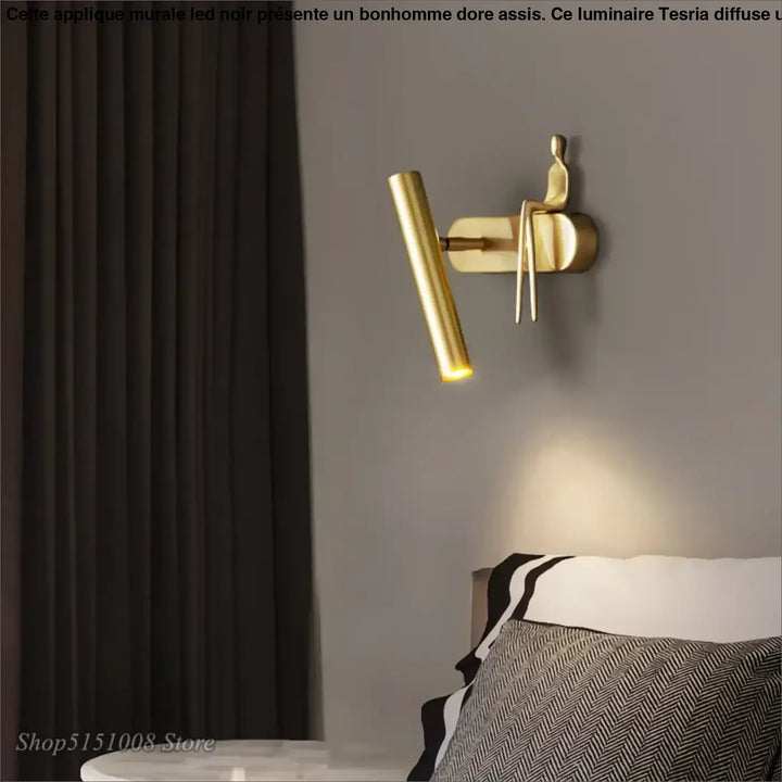 Applique murale LED noir avec un bonhomme doré assis

