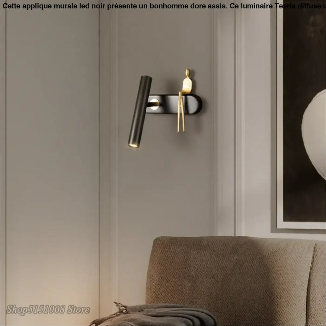 Applique murale LED noir avec un bonhomme doré assis

