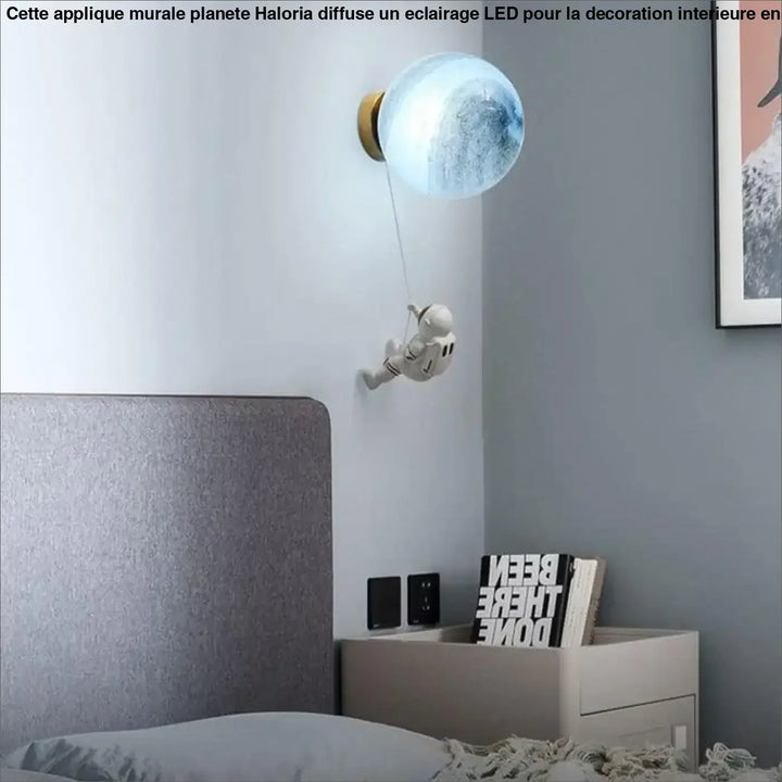Applique murale planete haloria sphérique translucide bleue avec base dorée et figurine astronaute suspendue