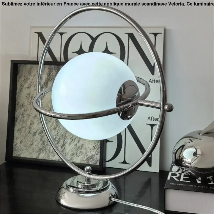 Lampe de table dessi avec globe blanc lumineux effet planète encadré de anneaux chromés sur base métallique élégante