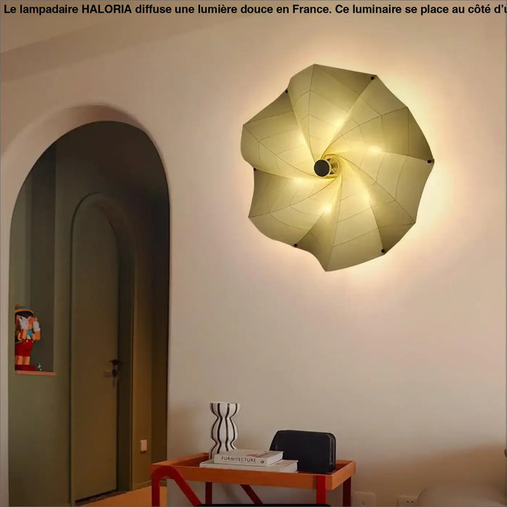 Un lampadaire grand lampadaire haloria cream coloré monté côté d’un canapé avec design géométrique en pétales et éclairage interne visible