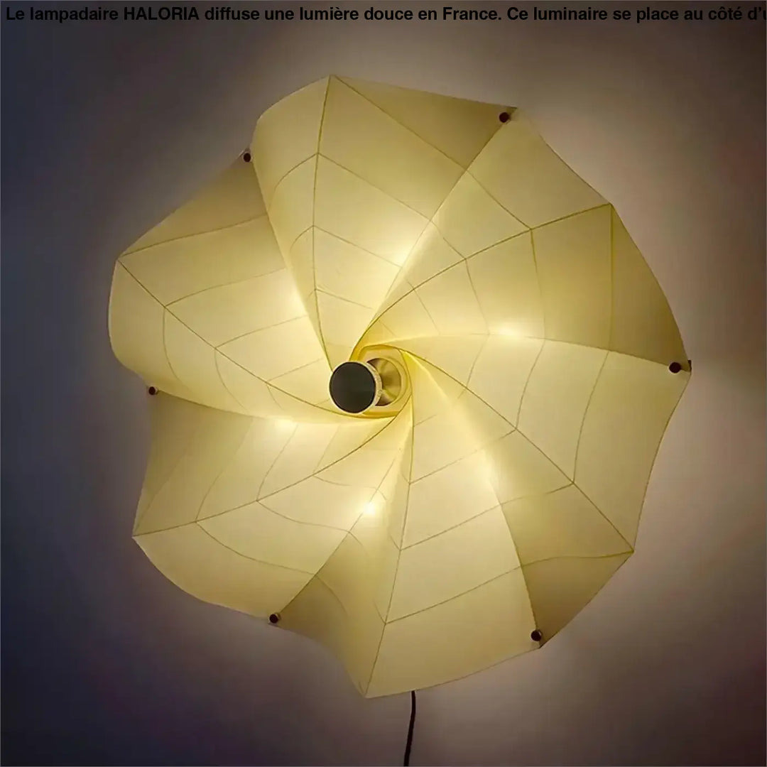 Un grand lampadaire haloria en papier crème avec design géométrique spiralé idéal côté d’un canapé
