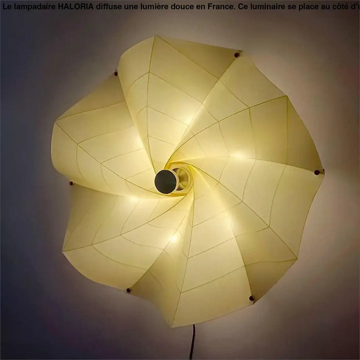 Un grand lampadaire haloria en papier crème avec design géométrique spiralé idéal côté d’un canapé