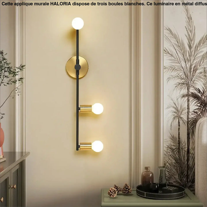 Grande applique murale haloria avec trois boules blanches, tige noire mate et accents dorés idéale long d’un couloir ou autour d’un miroir