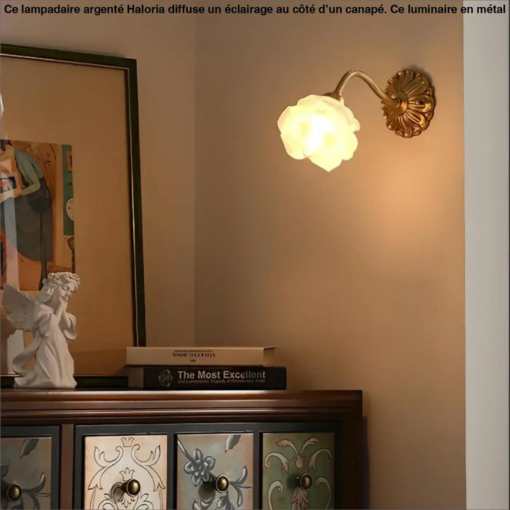 Lampadaire argente avec abat-jour floral en verre et base en métal doré orné côté d’un canapé