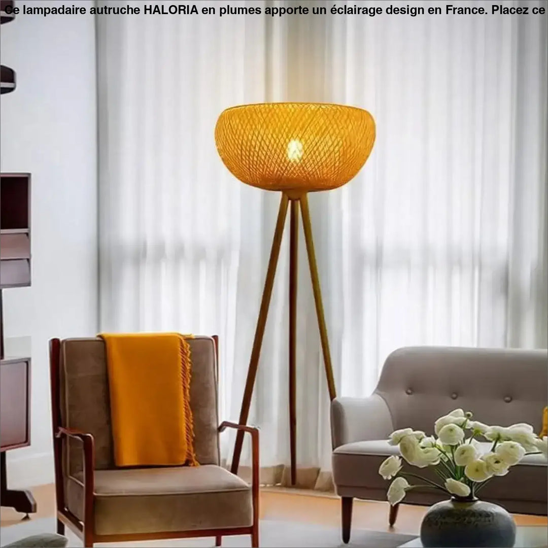Lampadaire autruche haloria avec abat-jour en bambou tissé et base tripode en bois côté d’un canapé