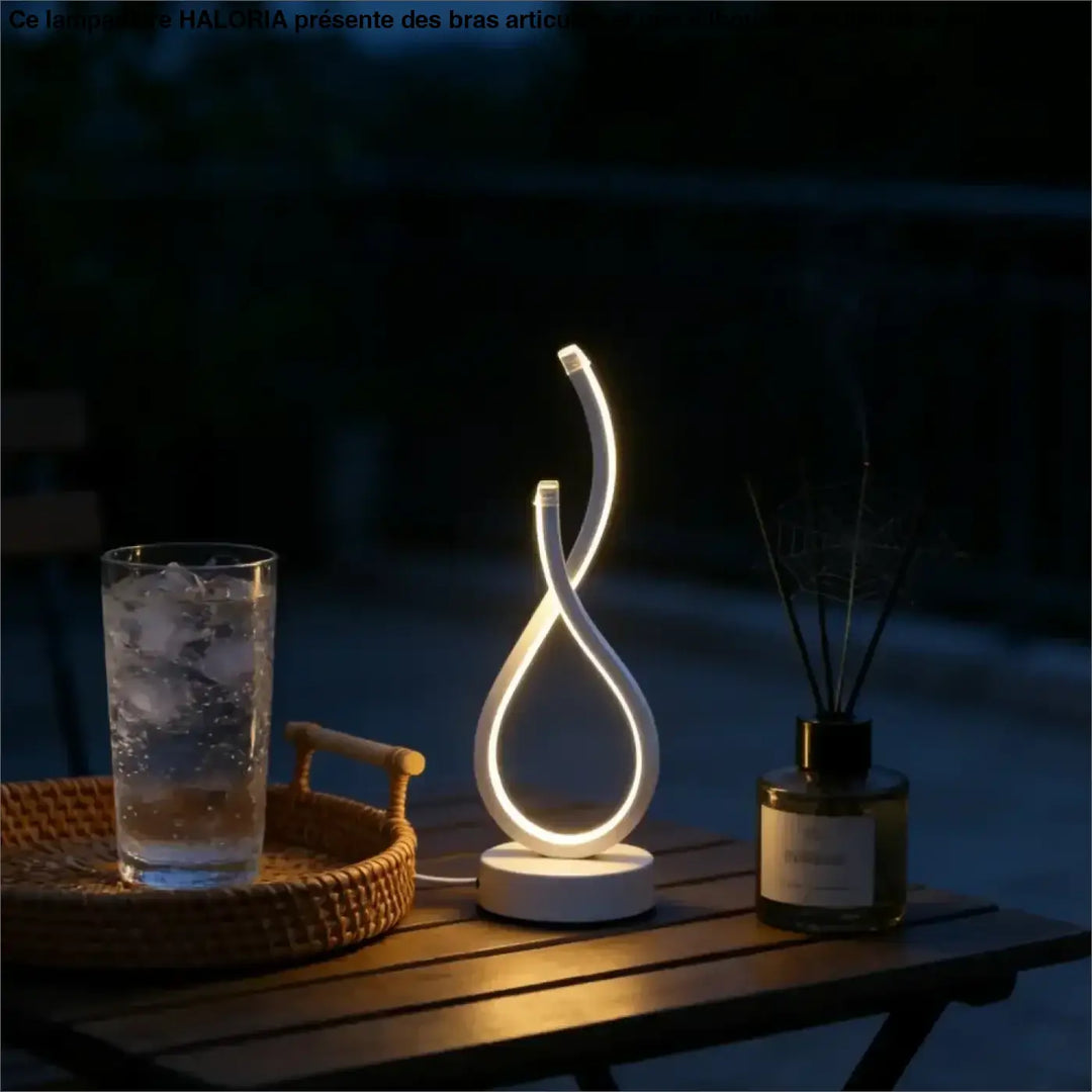 Lampe de table infinia blanche à boucle lumineuse moderne avec silhouette sculpturale posée sur table en bois