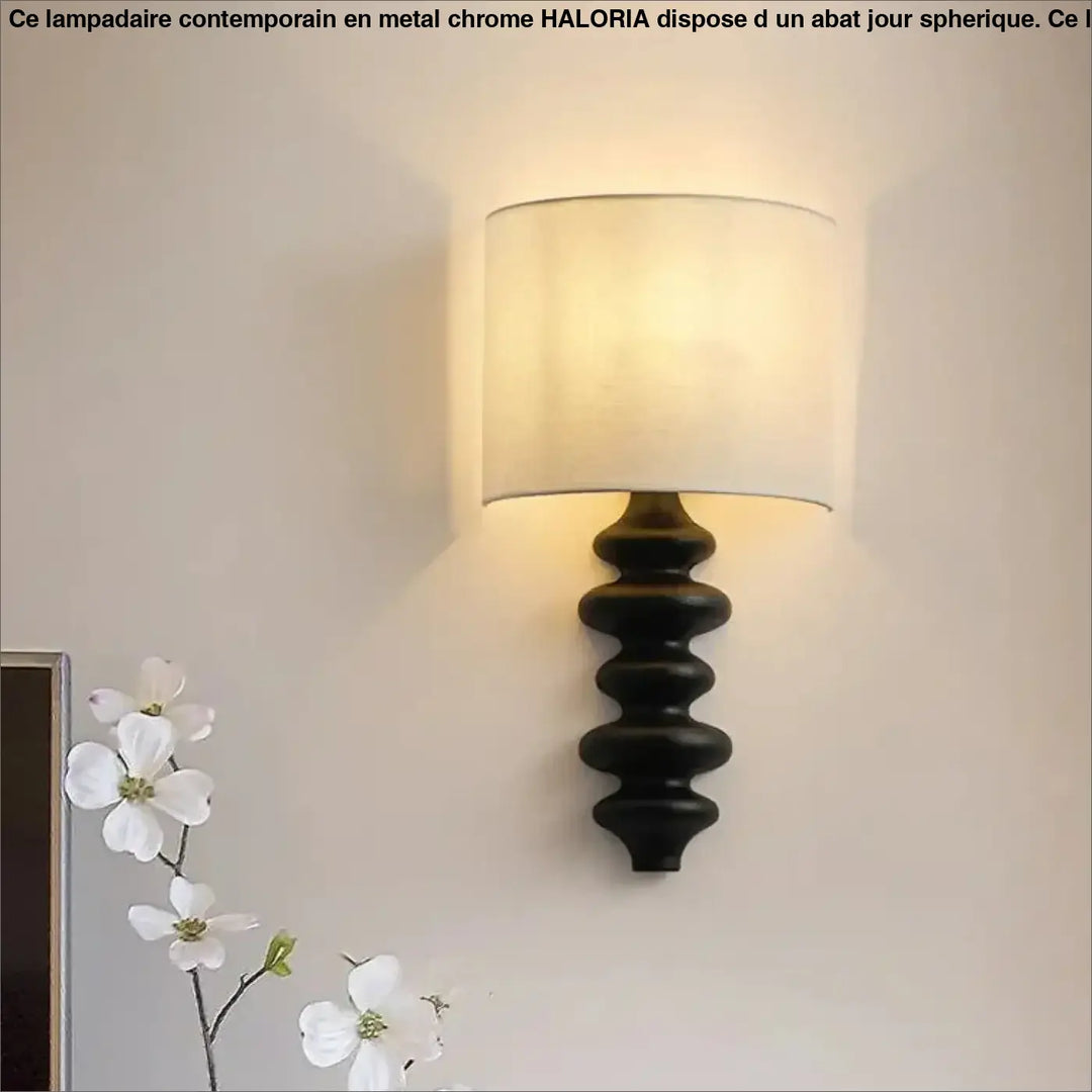 Applique murale en fer forgé noir avec abat-jour cylindrique en tissu écru offrant une lumière chaleureuse minimaliste