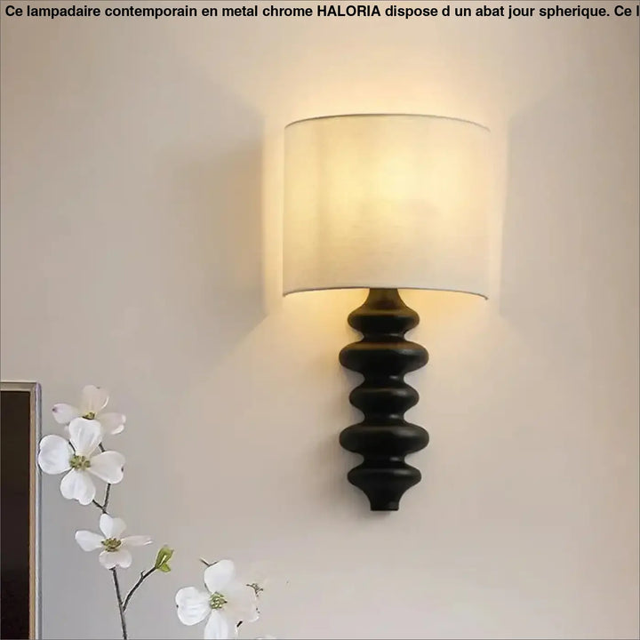 Applique murale en fer forgé noir avec abat-jour cylindrique en tissu écru offrant une lumière chaleureuse minimaliste