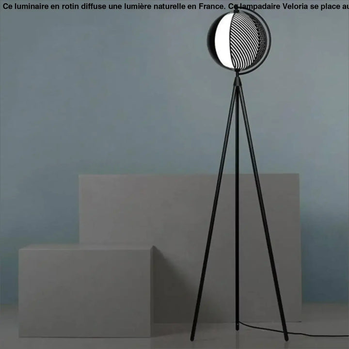 Lampadaire sur pied rotin veloria noir avec tête sphérique illuminée à motifs circulaires côté d’un canapé