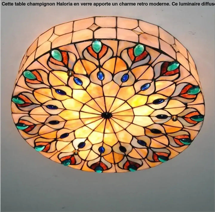 Luminaire plafonnier médiéval circulaire avec motif plume de paon en vitrail aux tons ambre orange et incrustations bleu teal
