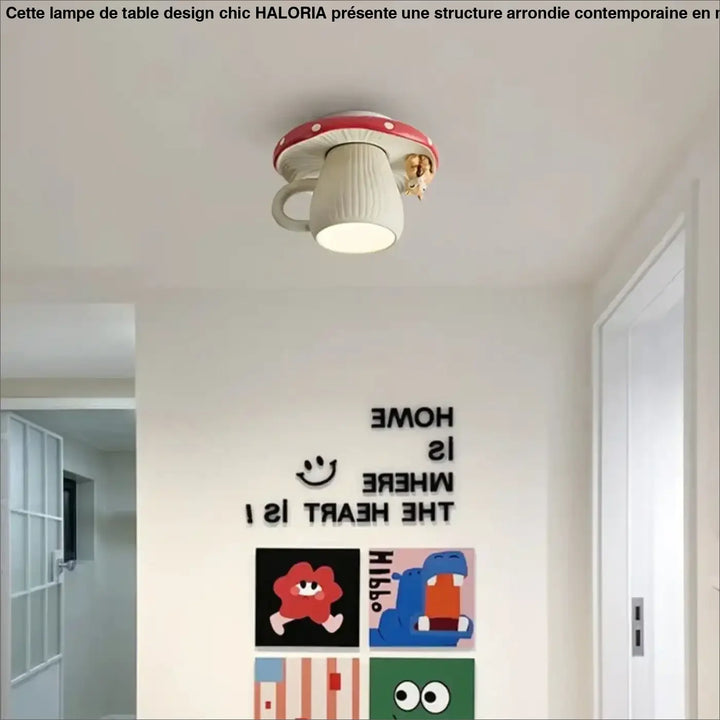 Une lampe de plafond fantaisiste en forme de champignon avec un chapeau rouge et un corps blanc texturé, présentant une petite créature dorée perchée sur son côté.