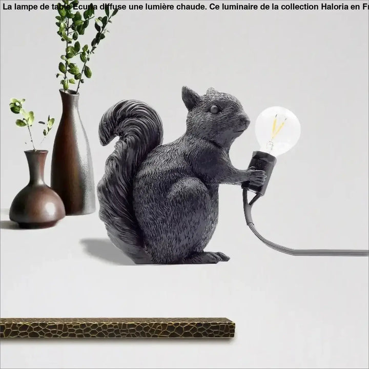 Lampe de table écureuil noire en résine avec surface texturée imitant la fourrure tenant une ampoule edison exposée design écureuil