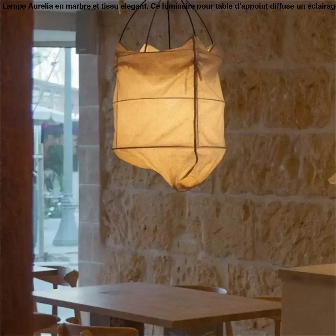 Suspension luminaire lima en tissu beige chaud avec style scandinave suspendue devant un mur en pierre rustique