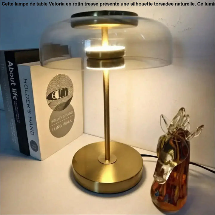 Lampe de table Zelia avec base et tige en métal doré et dôme en verre transparent diffusant une lumière chaleureuse