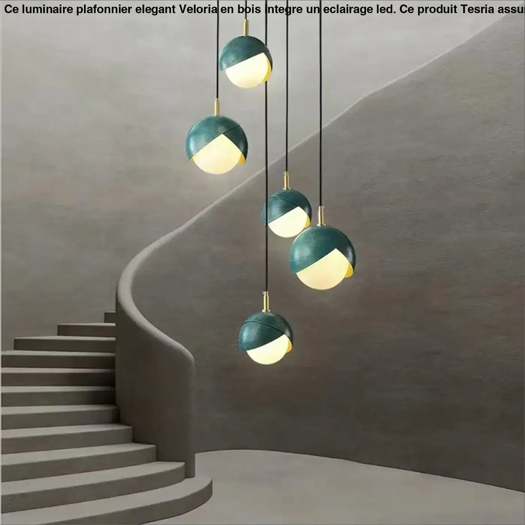 Luminaire plafonnier élégant en bois avec éclairage led, suspensions teal et or au design sphérique moderne au-dessus d’un escalier