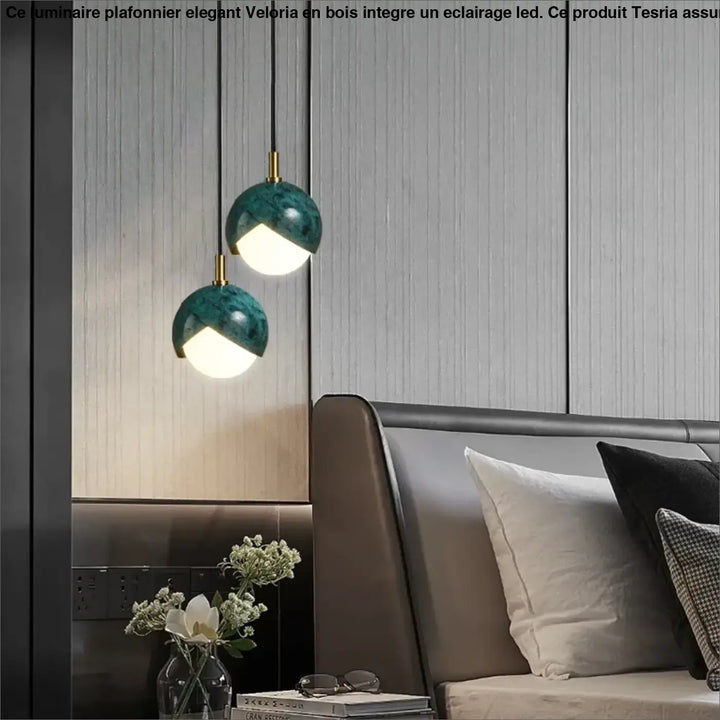 Deux luminaires plafonniers elegant en bois avec finition marbre teal et éclairage led suspendus au-dessus d’un lit moderne