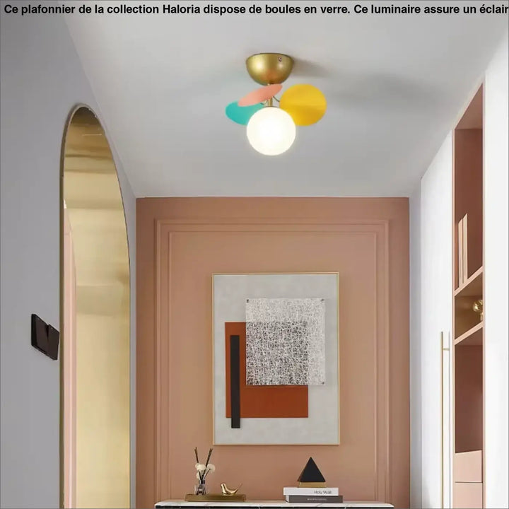 Plafonnier avec boules de la collection haloria avec base en laiton et trois abat-jours colorés autour du centre d’une blanc
