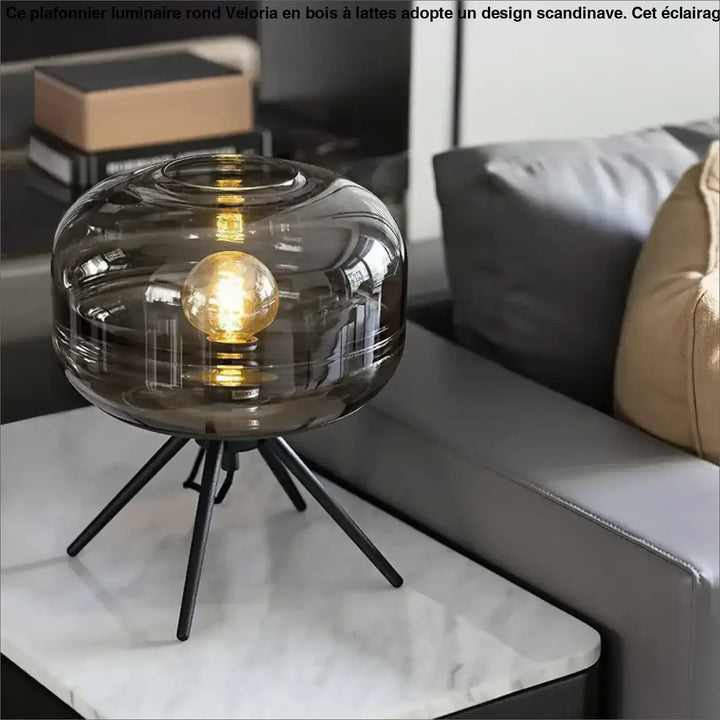 Lampe de table grisa en verre fumé avec base trépied design minimaliste et ampoule dorée exposée cadeau original