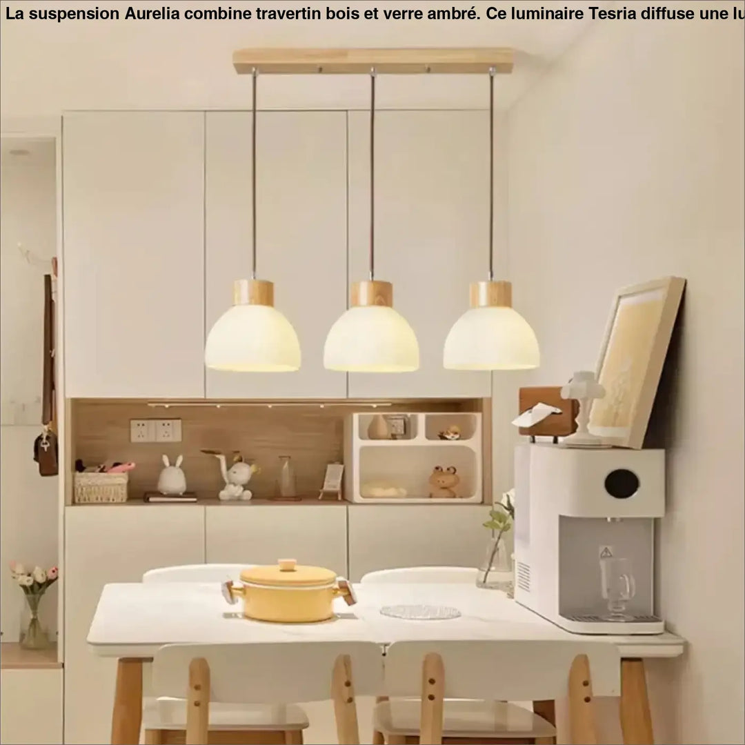 Suspension bois travertin verre ambre design elegant avec trois luminaires en verre dépoli au-dessus d’une table blanche