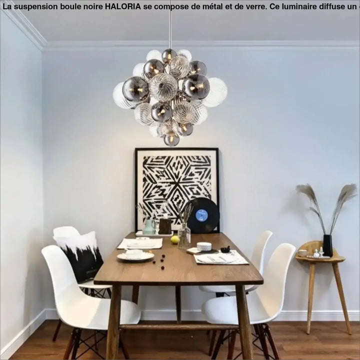 Suspension boule noire haloria en verre transparent et argent suspendue au-dessus d’une table en bois