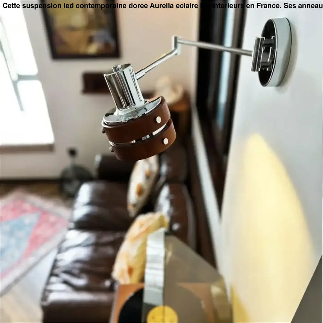 Suspension led contemporaine doree avec finition chrome, sangle en cuir marron et accents métalliques argentés pour lecture murale