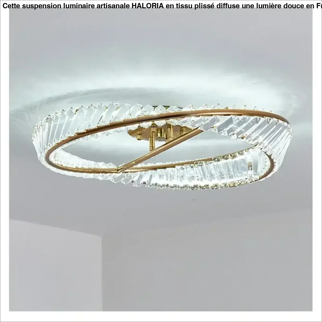 Un plafonnier double anneau moderne avec des montures en métal à teinte dorée et des éléments en cristal transparent, facettés.