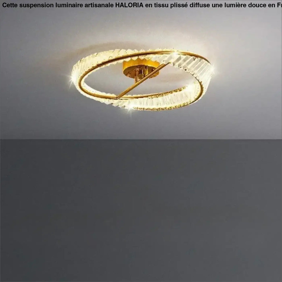 Lustre au plafond à finition dorée, doté de deux anneaux concentriques ornés d’éléments transparents, facettés, façon cristal.