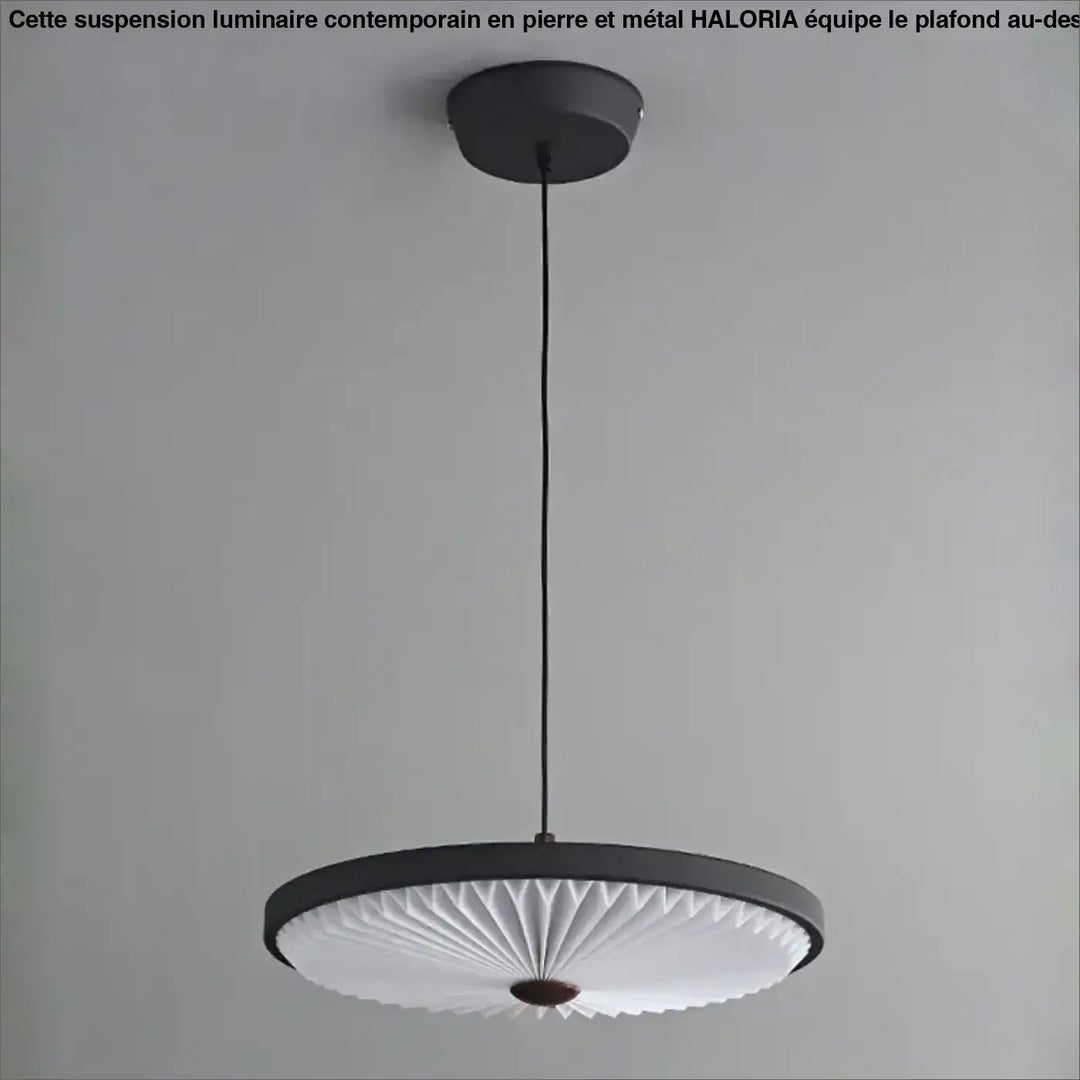 Suspension luminaire contemporain haloria en pierre et metal noir avec diffuseur plissé blanc et accent en bois au-dessus d’une table
