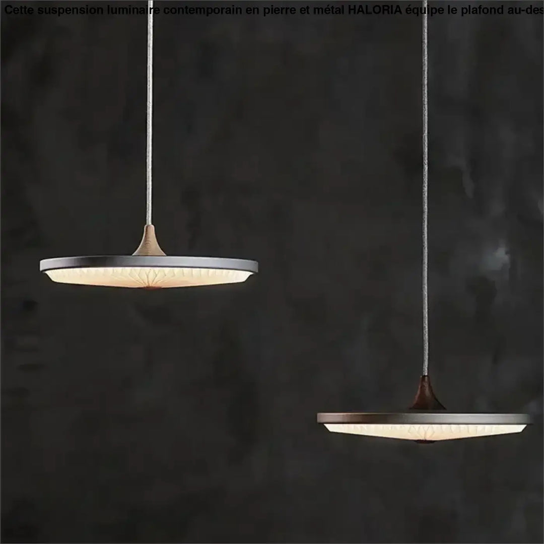 Deux suspensions luminaire contemporain en pierre et metal avec abat-jour rond en verre dépoli au-dessus d’une table