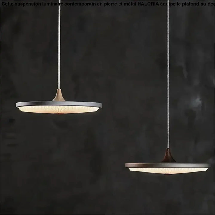 Deux suspensions luminaire contemporain en pierre et metal avec abat-jour rond en verre dépoli au-dessus d’une table