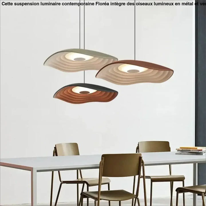 Suspension luminaire contemporaine floréa avec trois abat-jours ondulés en vert, beige et marron au-dessus d’une table à manger