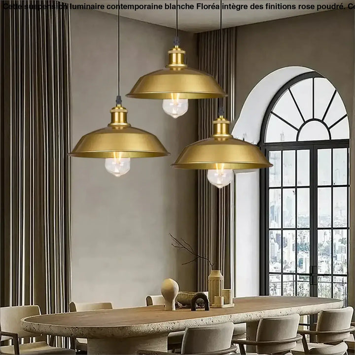 Trois suspensions luminaire industrielle dorée en laiton avec abat-jour en dôme et ampoules visibles au-dessus d’une table