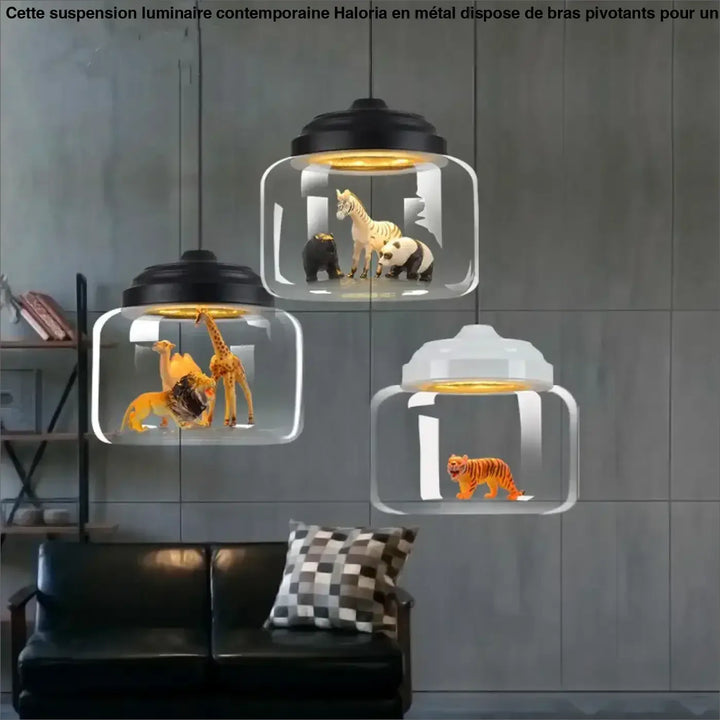 Suspension luminaire savon en verre transparent avec couvercles noirs et blancs contenant des animaux sauvages miniatures
