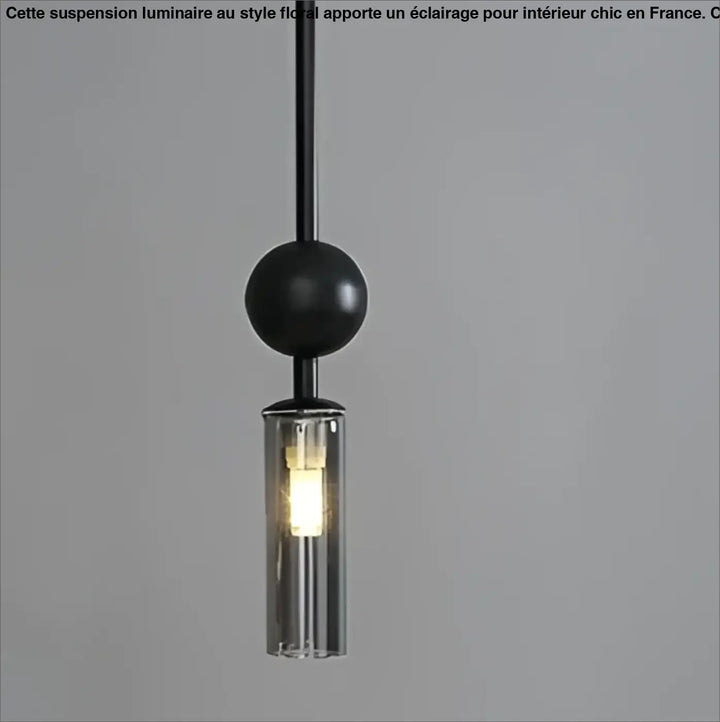 Suspension luminaire krysta avec boule métallique noire et cylindre en verre clair abritant lampoule