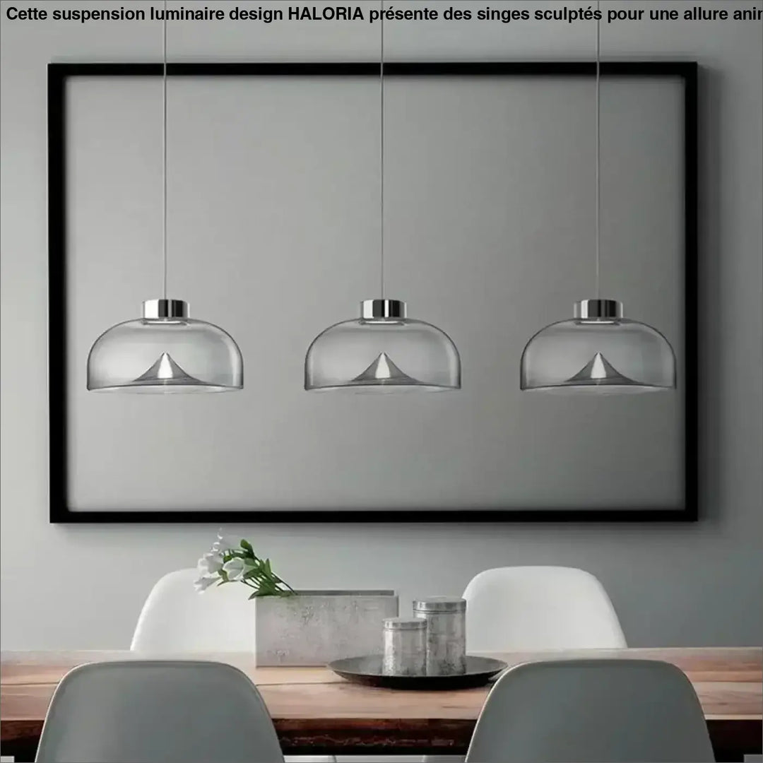 Suspension luminaire eclari avec trois suspensions en verre transparent fumé et fixations métalliques au-dessus d’une table à manger