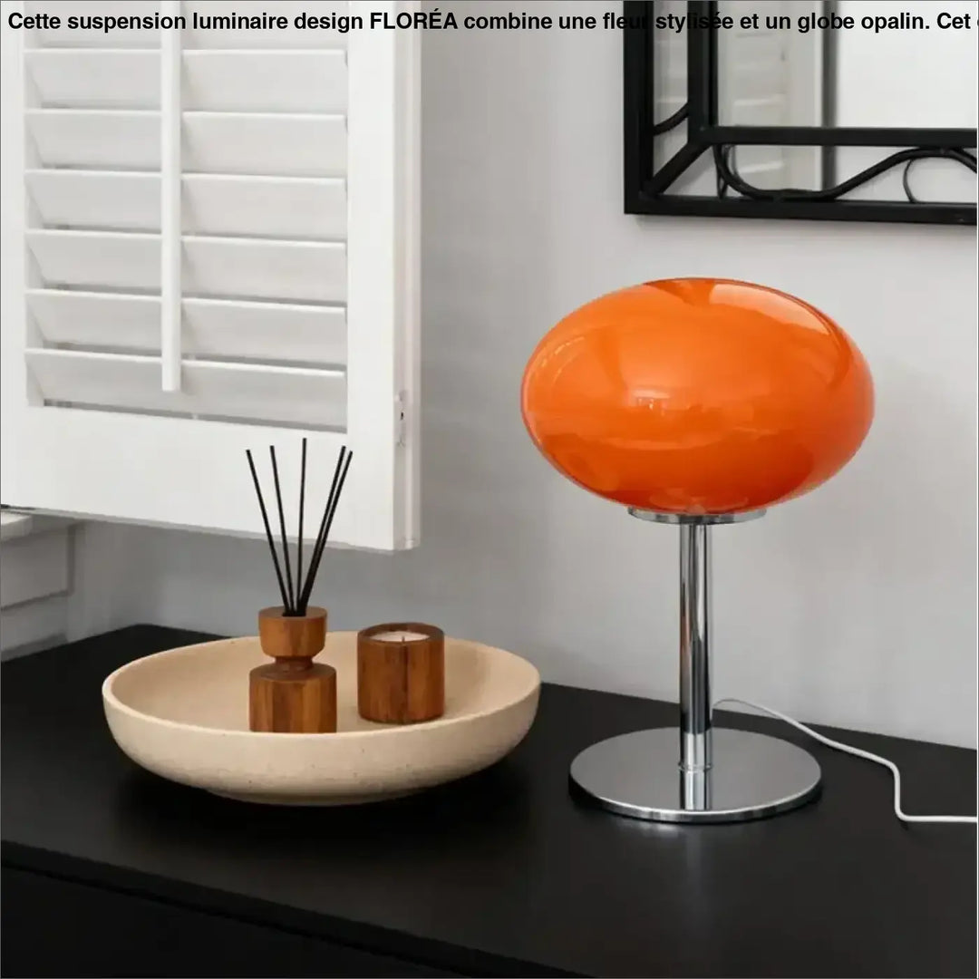 Lampe de chevet minimaliste avec globe en verre orange vibrant et base en chrome où la lumière devient plus qu’un accessoire