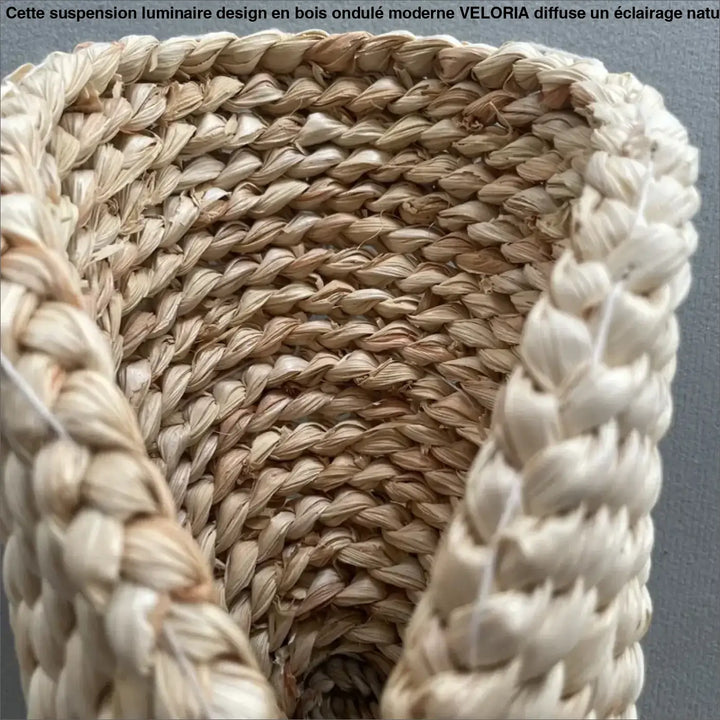 Une suspension luminaire design en bois ondule moderne avec un panier en paille tressée beige naturel