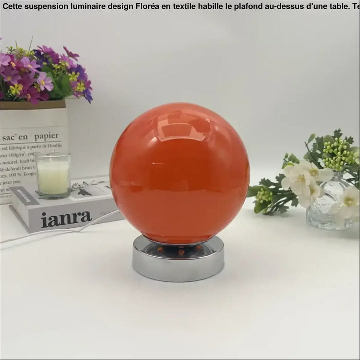 Lampe de chevet lange orange sphérique avec éclairage chaleureux sur socle chrome pour une lumière douce et plus qu’un décor