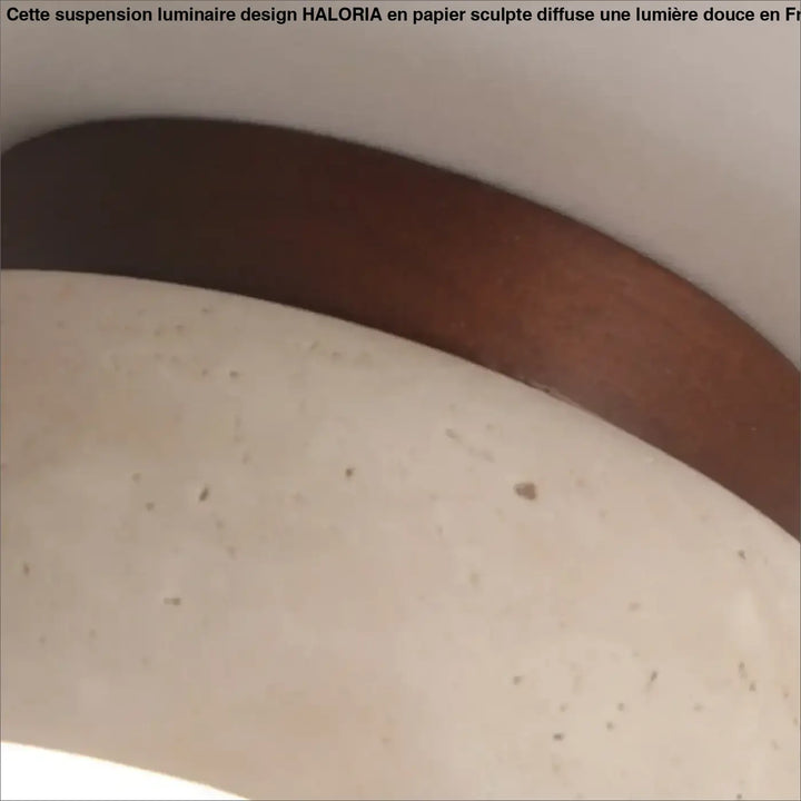 Sangle de ceinture en cuir brun foncé lisse pour suspension luminaire design en papier sculpté haloria sur surface beige