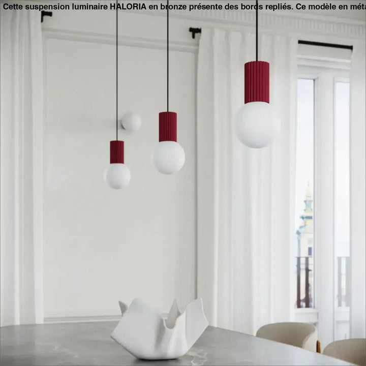 Trois lampes a poser halo bordeaux avec abat-jours globes cylindriques rouges et blancs suspendues par des cordons noirs